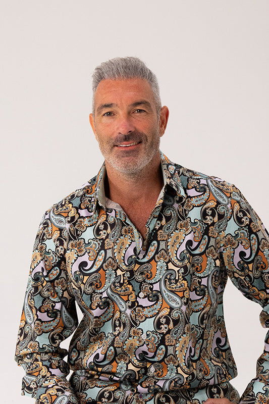 Man wearing a patterned shirt against a plain background