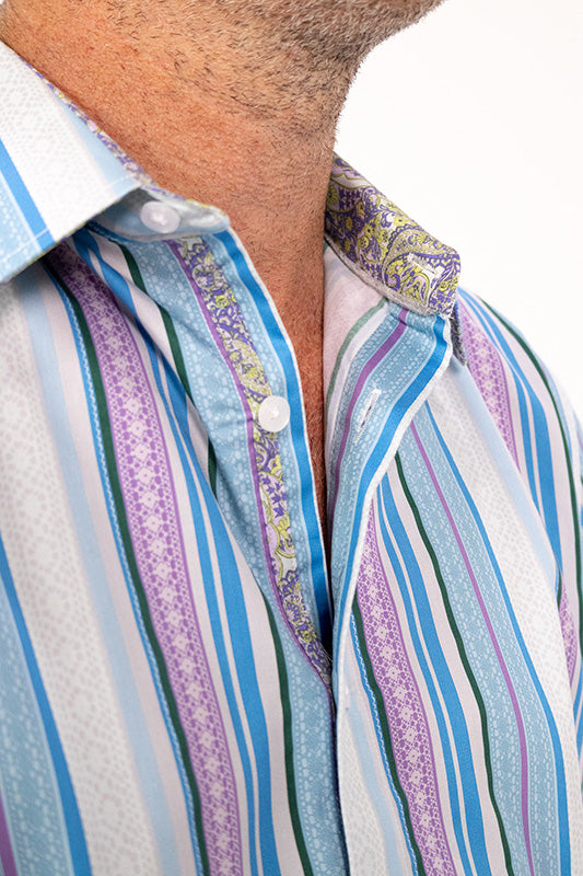Close-up of a man wearing a striped button-up shirt with vertical stripes in blue, purple, green, and white, featuring a patterned inner collar.