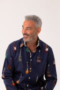 Man wearing a navy blue shirt with guitar pattern on a white background