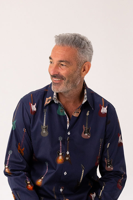 Man wearing a navy blue shirt with guitar pattern on a white background