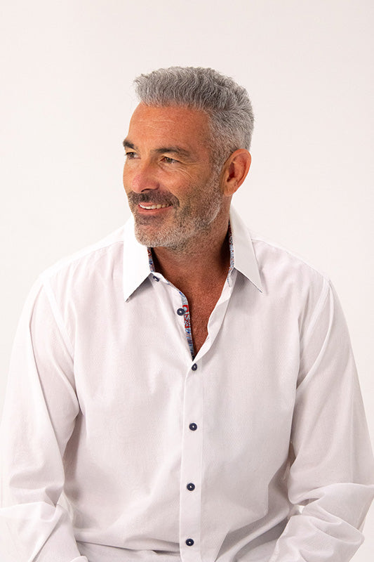 Man wearing a white dress shirt against a plain background