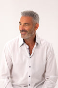 Man wearing a white dress shirt against a plain background