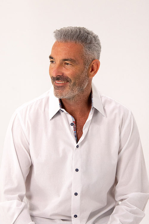 Man wearing a white dress shirt against a plain background