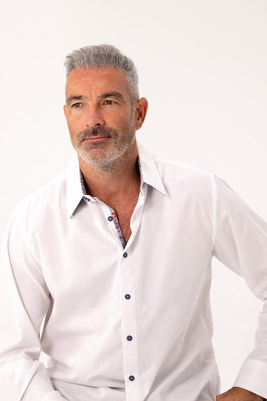 Man wearing a white dress shirt with a patterned collar on a white background